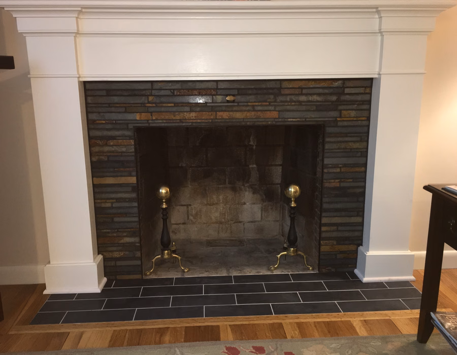 Brick fireplace with a white mantel and dark tiled hearth