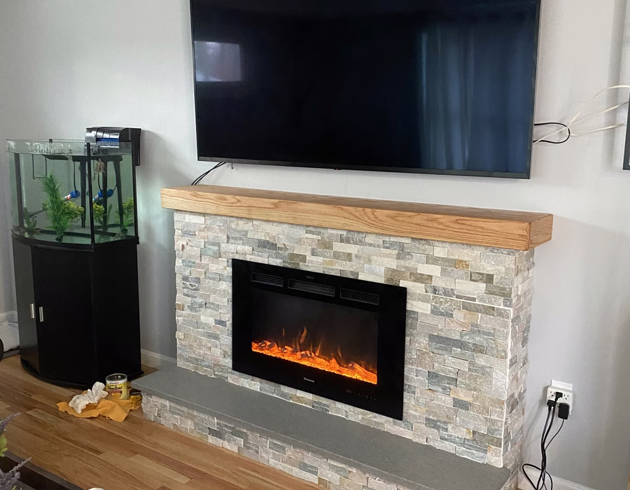 Stone-faced fireplace with a wood mantel and wall-mounted television