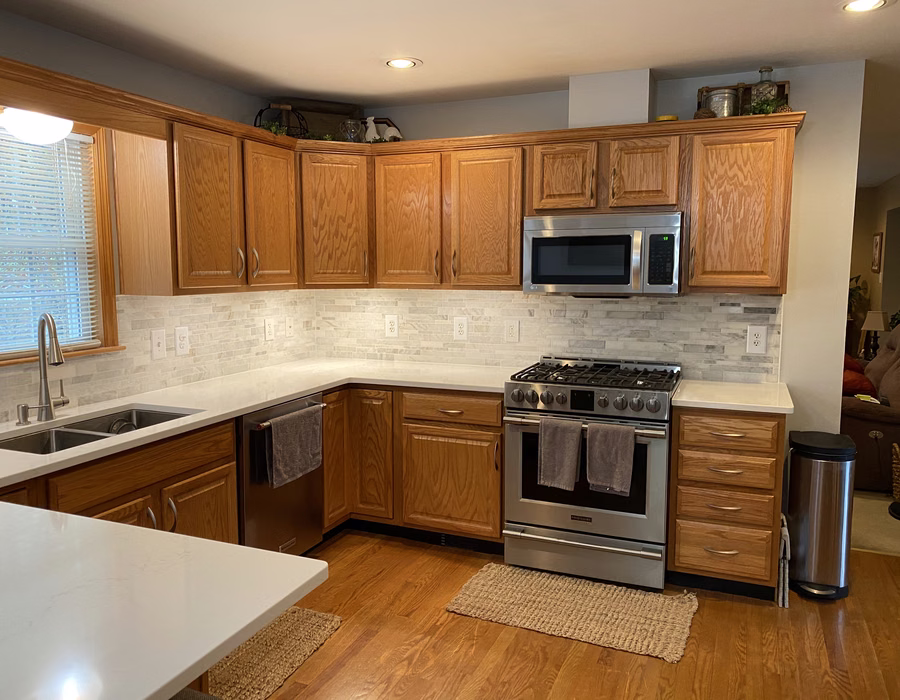 Kitchen with quartz countertops, tile backsplash, and stainless appliances